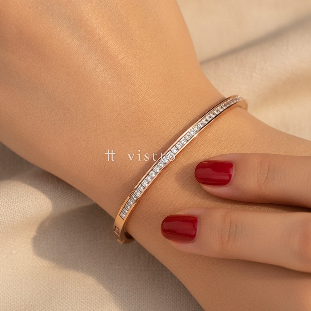 Pulsera en oro rosa fina, diseño de brazalete rígido con fila de circonias cúbicas transparentes en talla cuadrada y cierre de bisagra