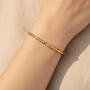 Pulsera dorada fina y abierta, diseño de brazalete de piezas ovaladas unidas por pequeñas bolitas y acabado brillante