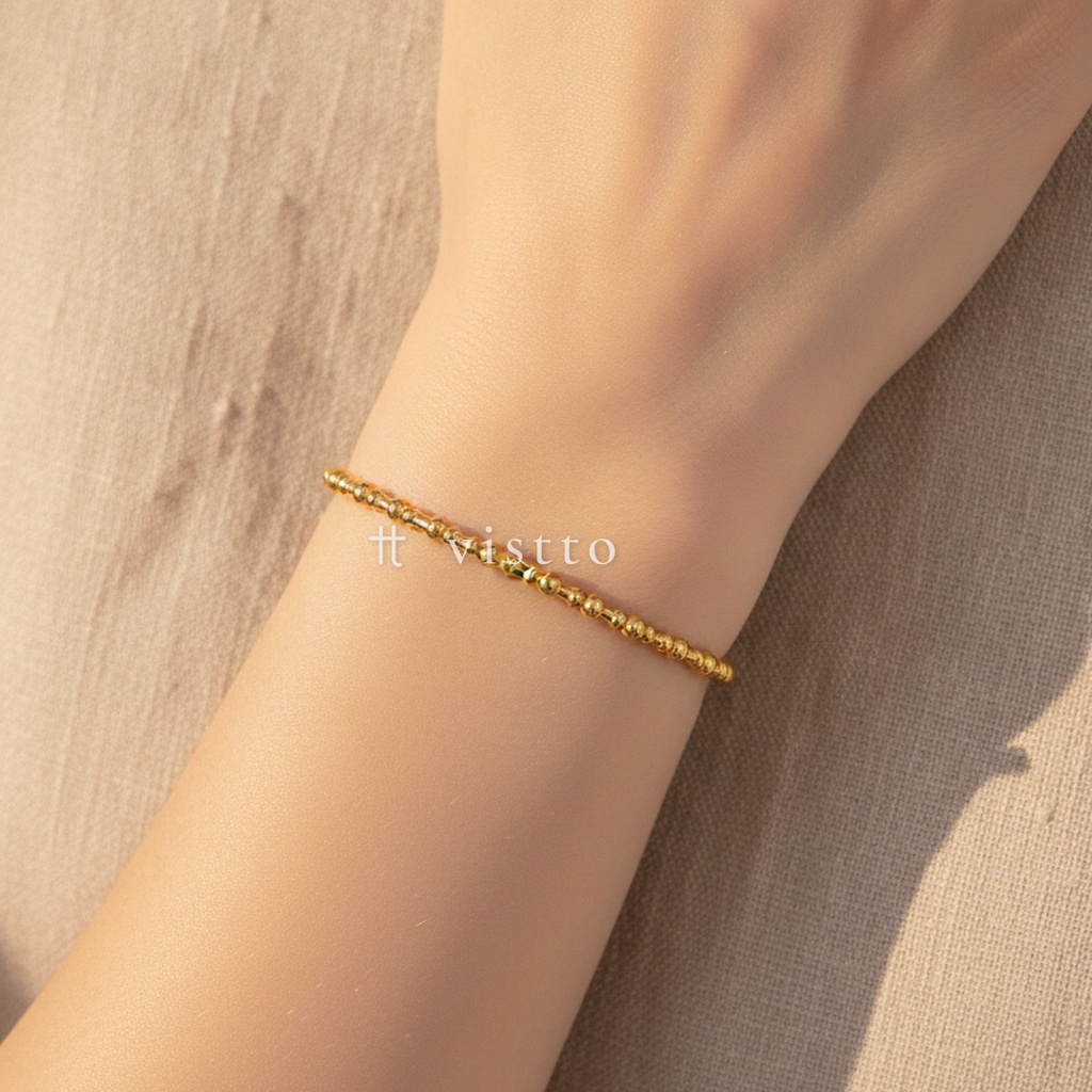 Pulsera dorada fina y abierta, diseño de brazalete de bolitas y segmentos cortos alternados con acabado brillante