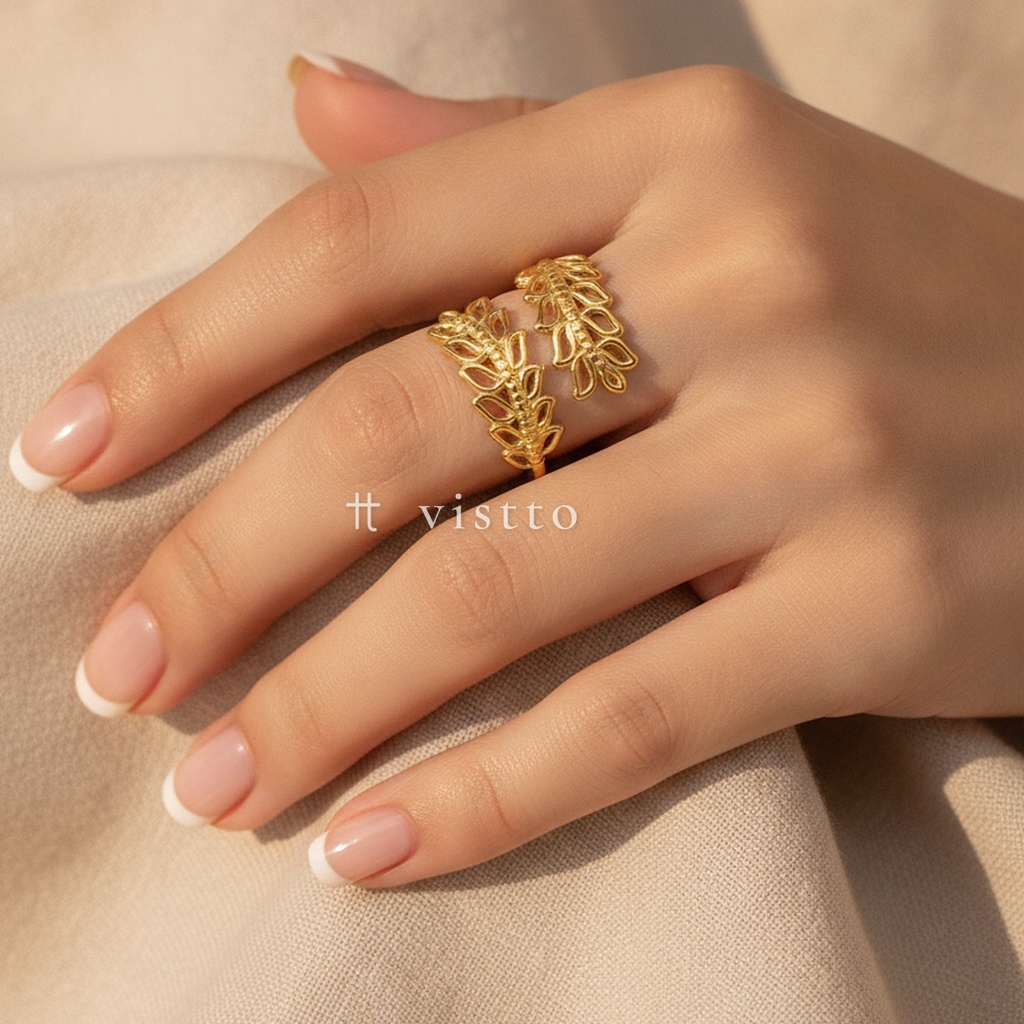 Anillo dorado ancho y abierto, diseño envolvente de dos ramas con hojas caladas y acabado brillante