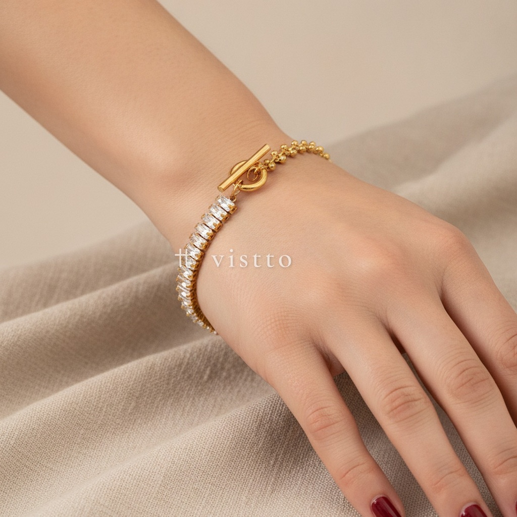 Pulsera dorada con cierre de barra y argolla, diseño combinado de hilera de circonias cúbicas transparentes en talla baguette y cadena de espiga con cuentas
