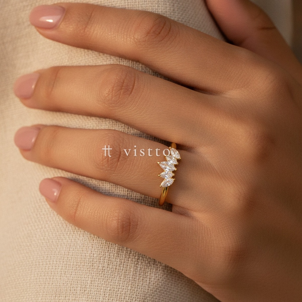 Anillo dorado fino y abierto, diseño de aro liso con motivo frontal en forma de corona de cinco circonias transparentes en talla marquesa