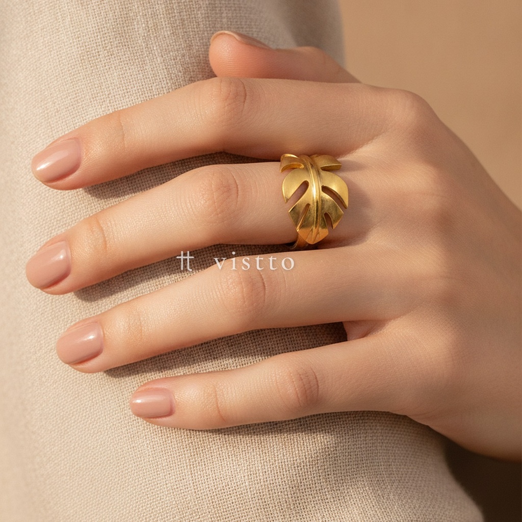 Anillo dorado ancho y abierto, diseño envolvente en forma de hoja de monstera con cortes calados y acabado brillante
