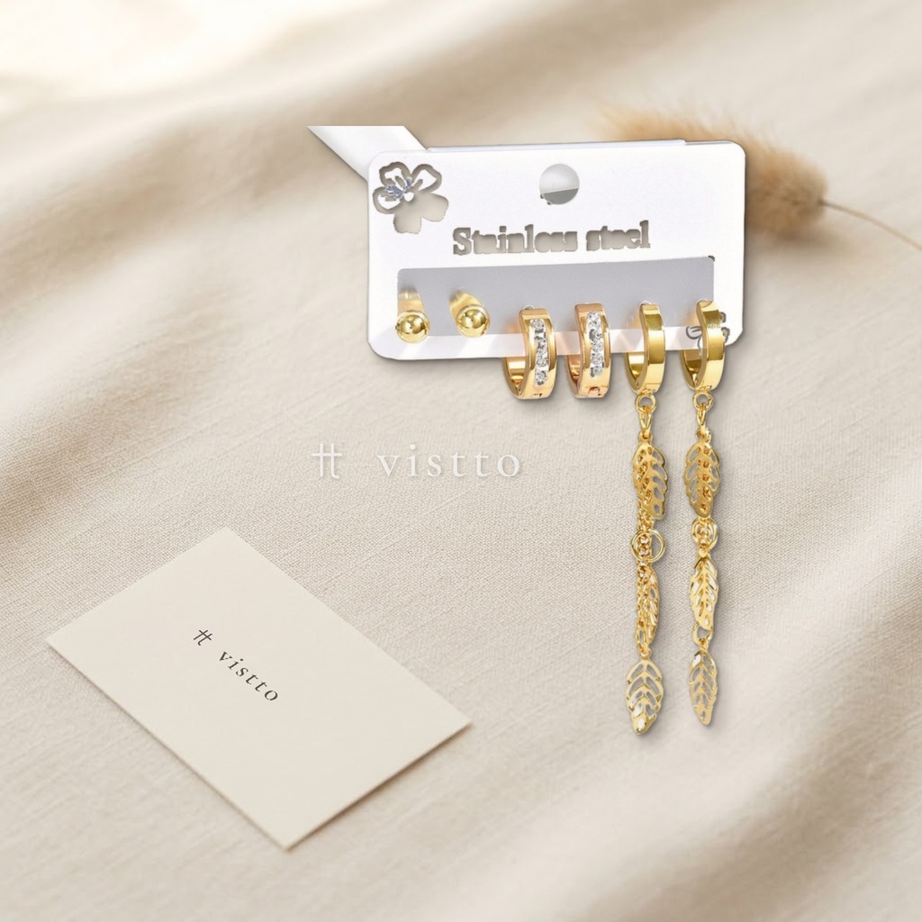 Set de tres pares de zarcillos dorados, con botón liso, huggie de circonias cúbicas transparentes en canal y huggie con cadena de hojas caladas colgantes