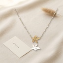 Collar dorado de cadena fina con puntos de esmalte blanco y flor central de cinco pétalos texturizados