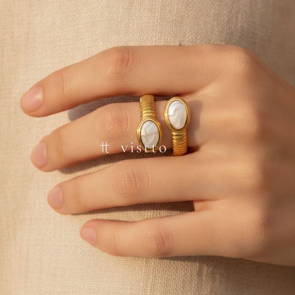 Anillo dorado y blanco abierto, diseño de dos extremos enfrentados con cabujones ovalados de esmalte blanco y brazo acanalado