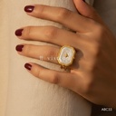 Anillo dorado abierto, sello octogonal con estrella y esmalte blanco