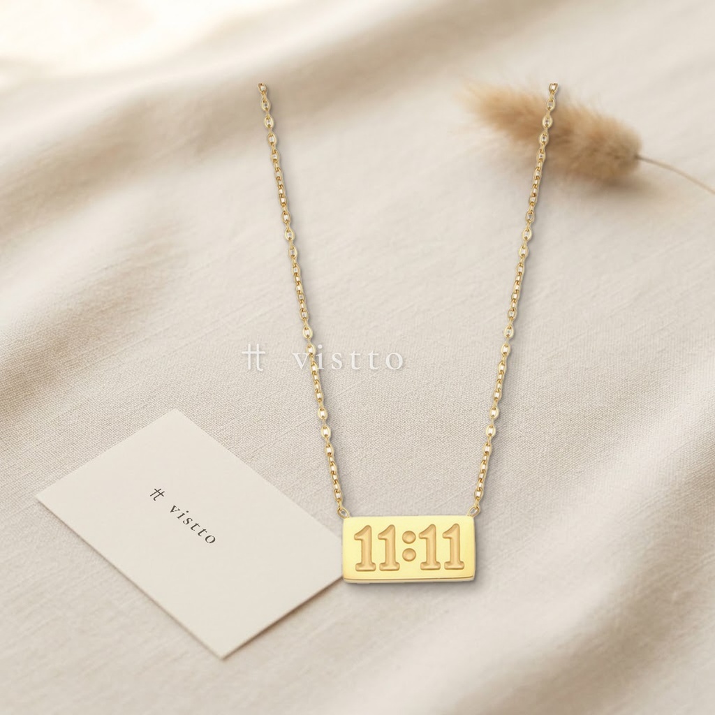 Collar dorado de cadena fina con placa rectangular grabada con el número 11:11