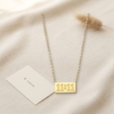 Collar dorado de cadena fina con placa rectangular grabada con el número 11:11