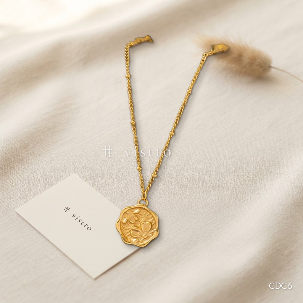 Collar dorado, bolitas y medallón de flor