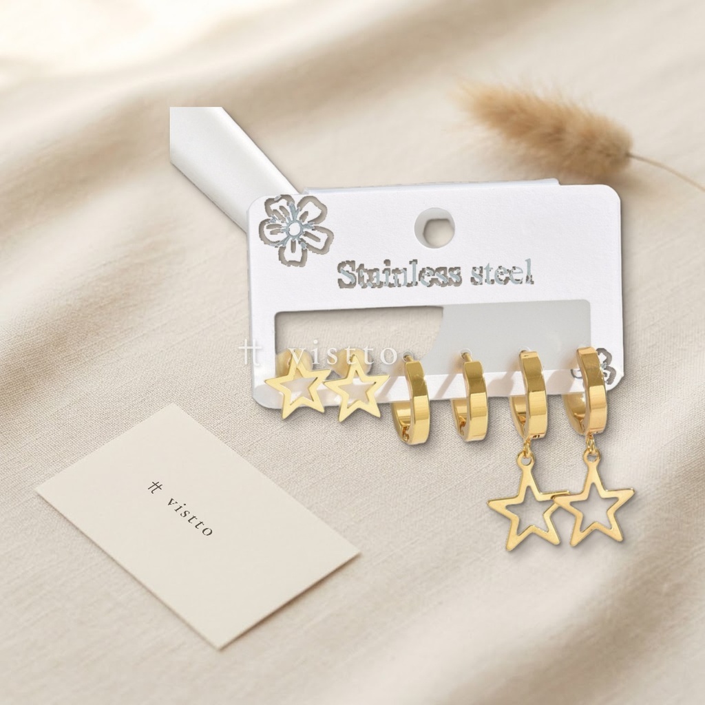 Set de tres pares de zarcillos dorados, con tachuela de estrella calada, argolla huggie lisa y argolla huggie con estrella calada colgante
