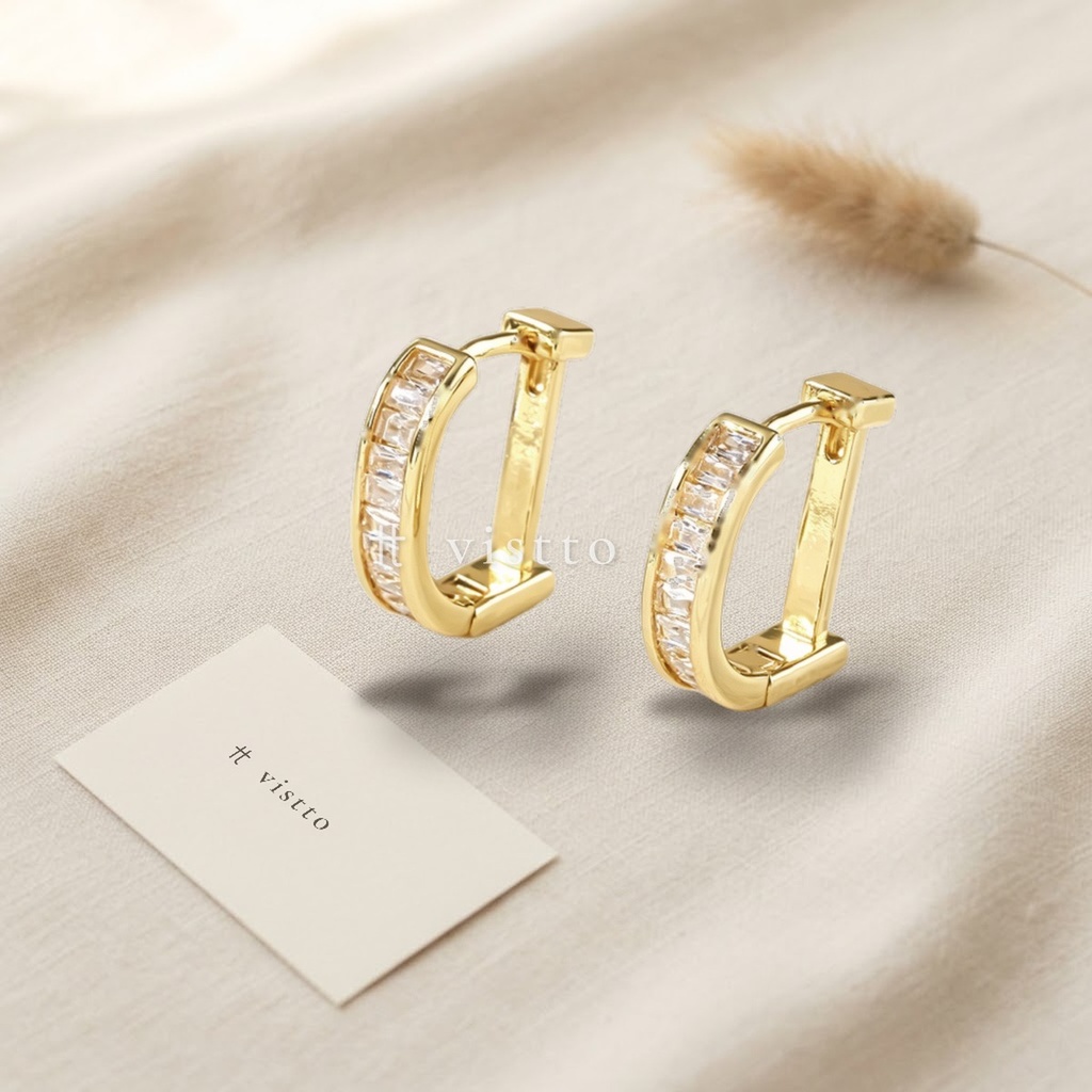 Zarcillos dorados en argolla de forma rectangular, diseño con hilera de circonias cúbicas transparentes talla baguette y acabado brillante