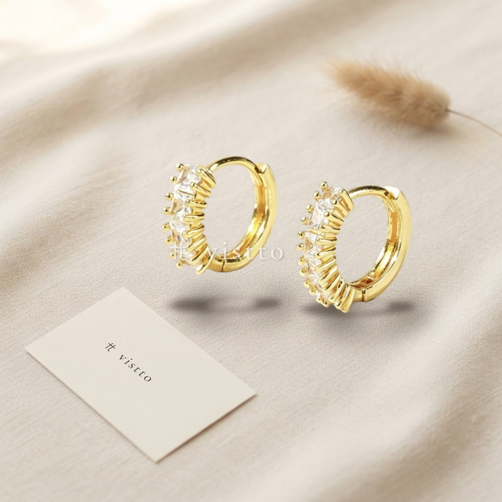 Zarcillos dorados de argolla huggie con fila de circonias transparentes engastadas en garras