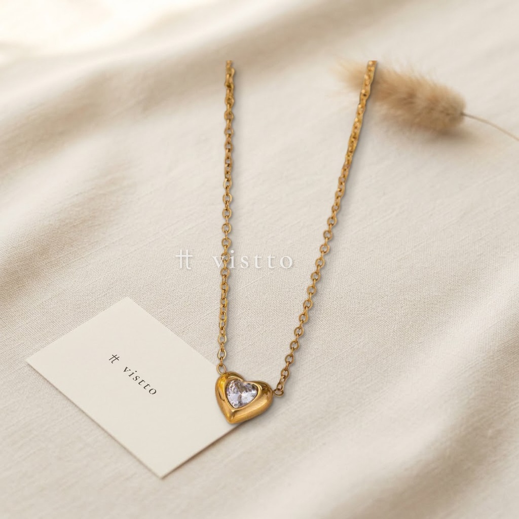 Collar dorado de cadena fina con dije de corazón abombado y una circonia transparente en talla corazón