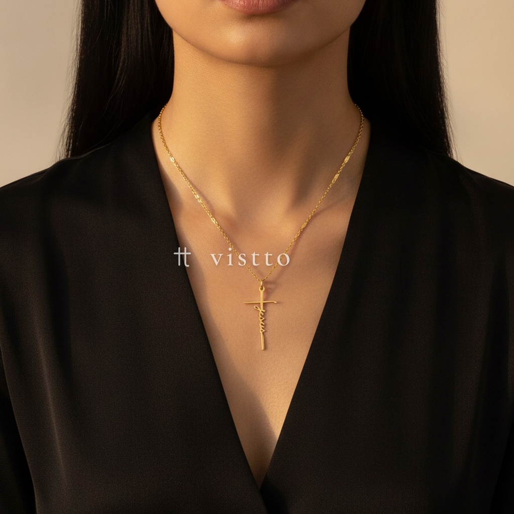 Collar dorado de cadena de eslabones planos con dije de cruz alargada formada por la palabra Jesús en caligrafía
