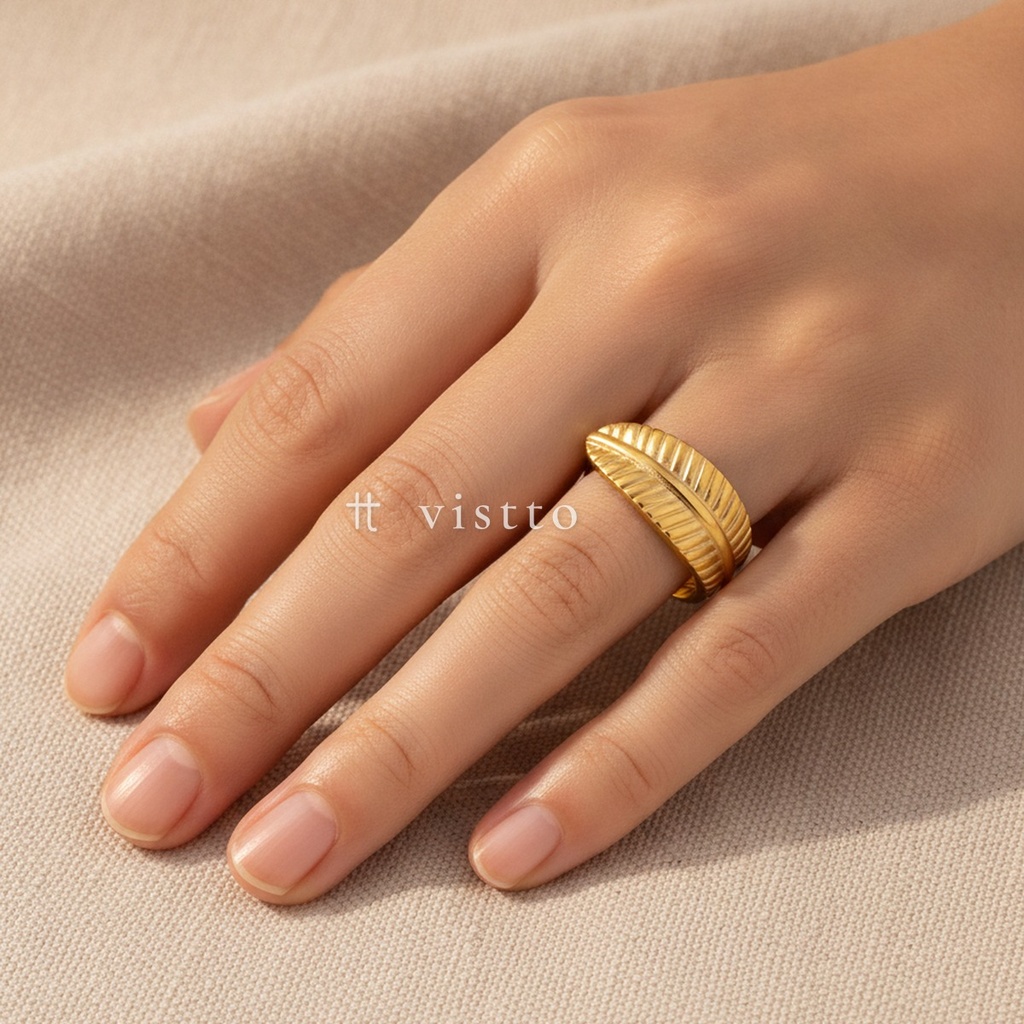 Anillo dorado ancho y abierto, diseño envolvente en forma de hoja con nervaduras texturizadas y acabado brillante