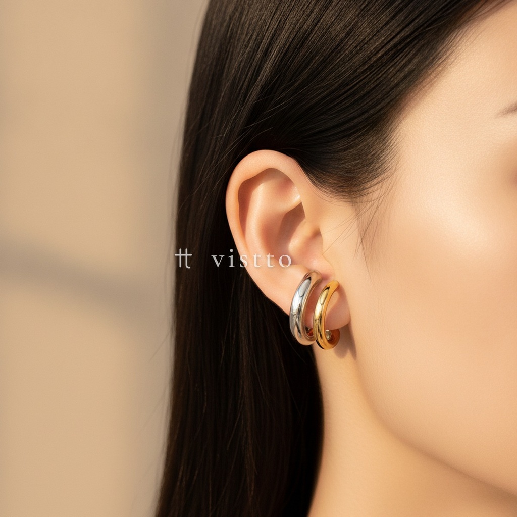 Earcuff bicolor de doble banda en C, una banda ancha plateada y otra fina dorada, de ajuste a presión