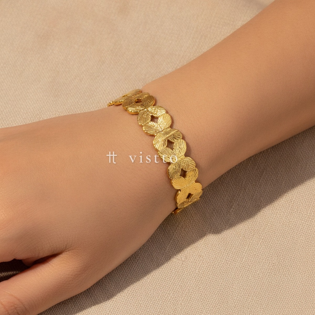 Pulsera dorada abierta, diseño de brazalete con hilera de mariposas de alas grabadas y acabado brillante