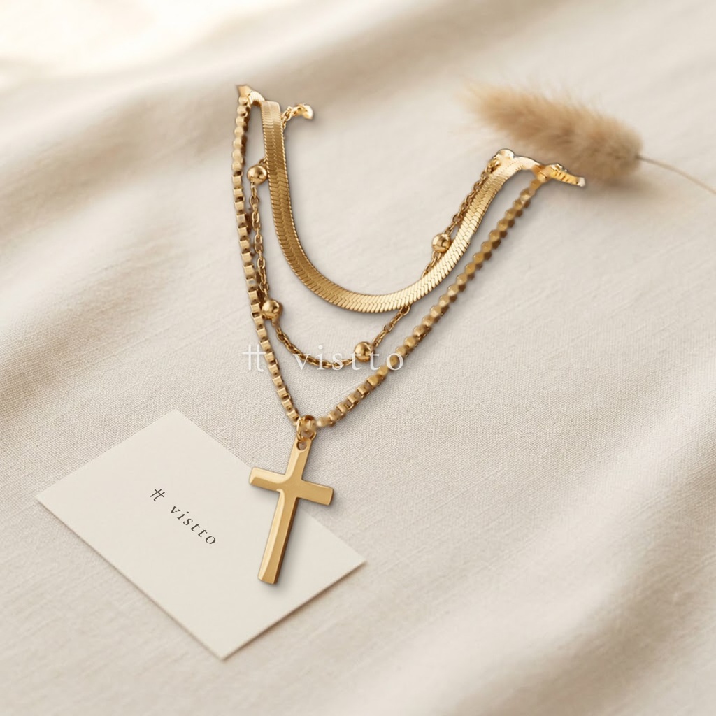 Collar dorado en capas de tres cadenas de distinto diseño, con dije de cruz lisa colgando de la más larga
