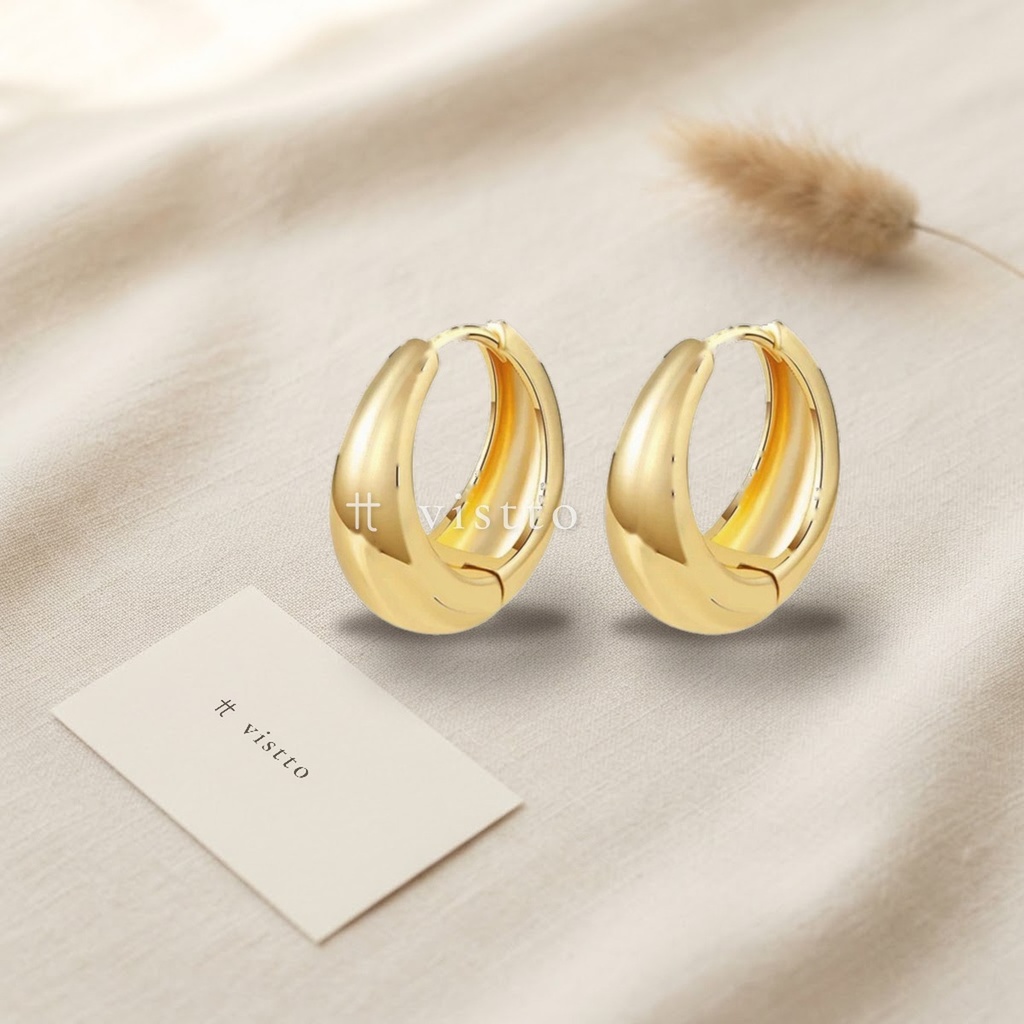 Zarcillos dorados de argolla huggie ovalada y abombada con acabado liso brillante