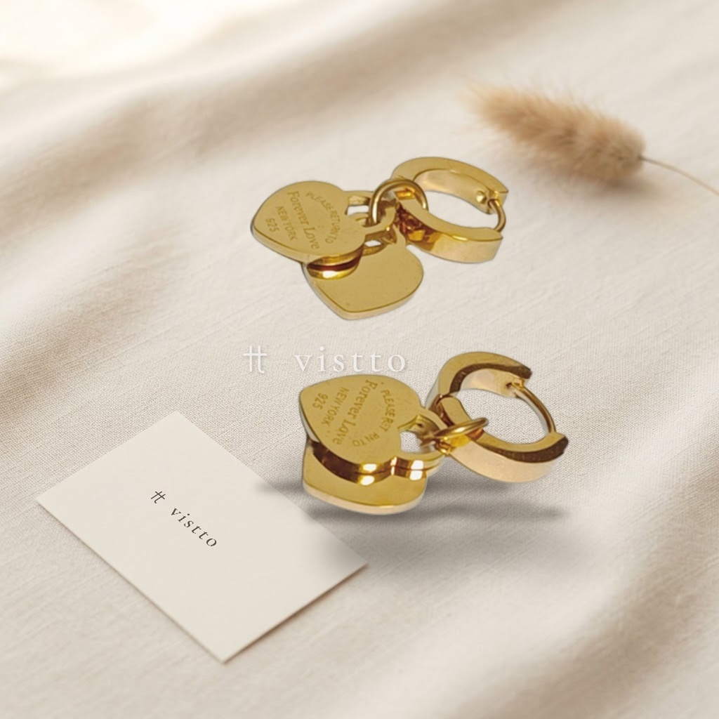 Zarcillos dorados de argolla huggie con dos dijes de corazón liso colgantes y grabado en el reverso