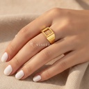 Anillo dorado ancho y abierto, diseño de banda lisa con motivo frontal de la letra E calada y acabado brillante