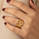 Anillo dorado ancho y abierto, diseño de banda lisa con motivo frontal de la letra G calada y acabado brillante