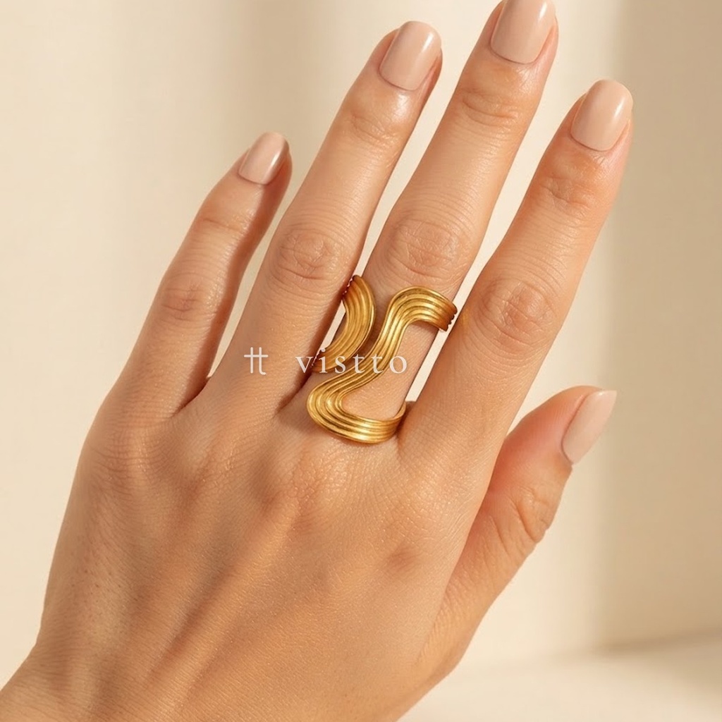 Anillo dorado ancho y abierto, diseño envolvente de banda ondulada asimétrica con líneas concéntricas y acabado brillante