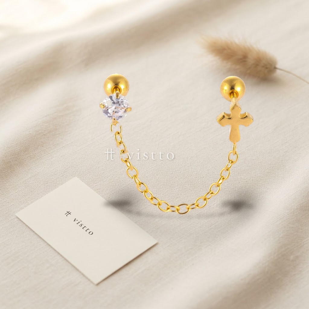 Zarcillos dorados de doble piercing unidos por cadena fina, con circonia transparente y motivo de cruz