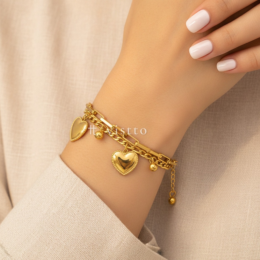 Pulsera dorada de grosor estándar, diseño de doble cadena de eslabones alargados y barbada con dos corazones y bolitas colgantes
