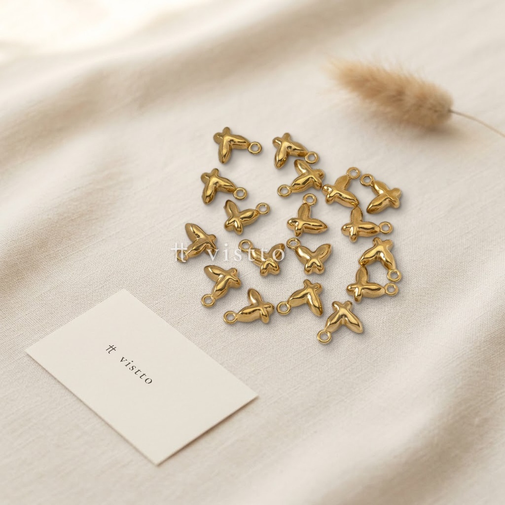 Dije dorado en forma de mariposa pequeña con relieve y argolla superior para colgar
