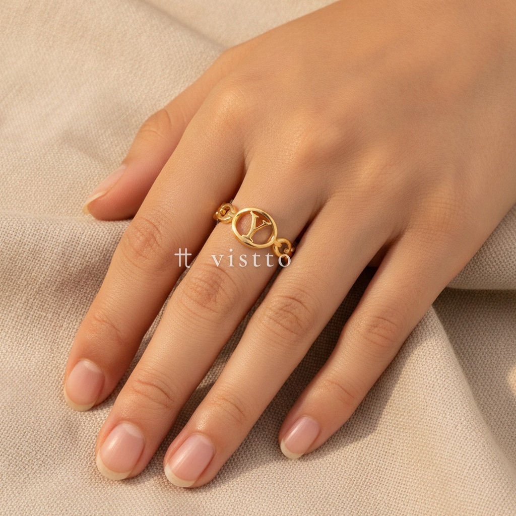 Anillo dorado fino y abierto, diseño de banda de eslabones con medallón ovalado calado y letra Y central, acabado liso y brillante